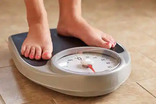 woman feet on weighing scale=